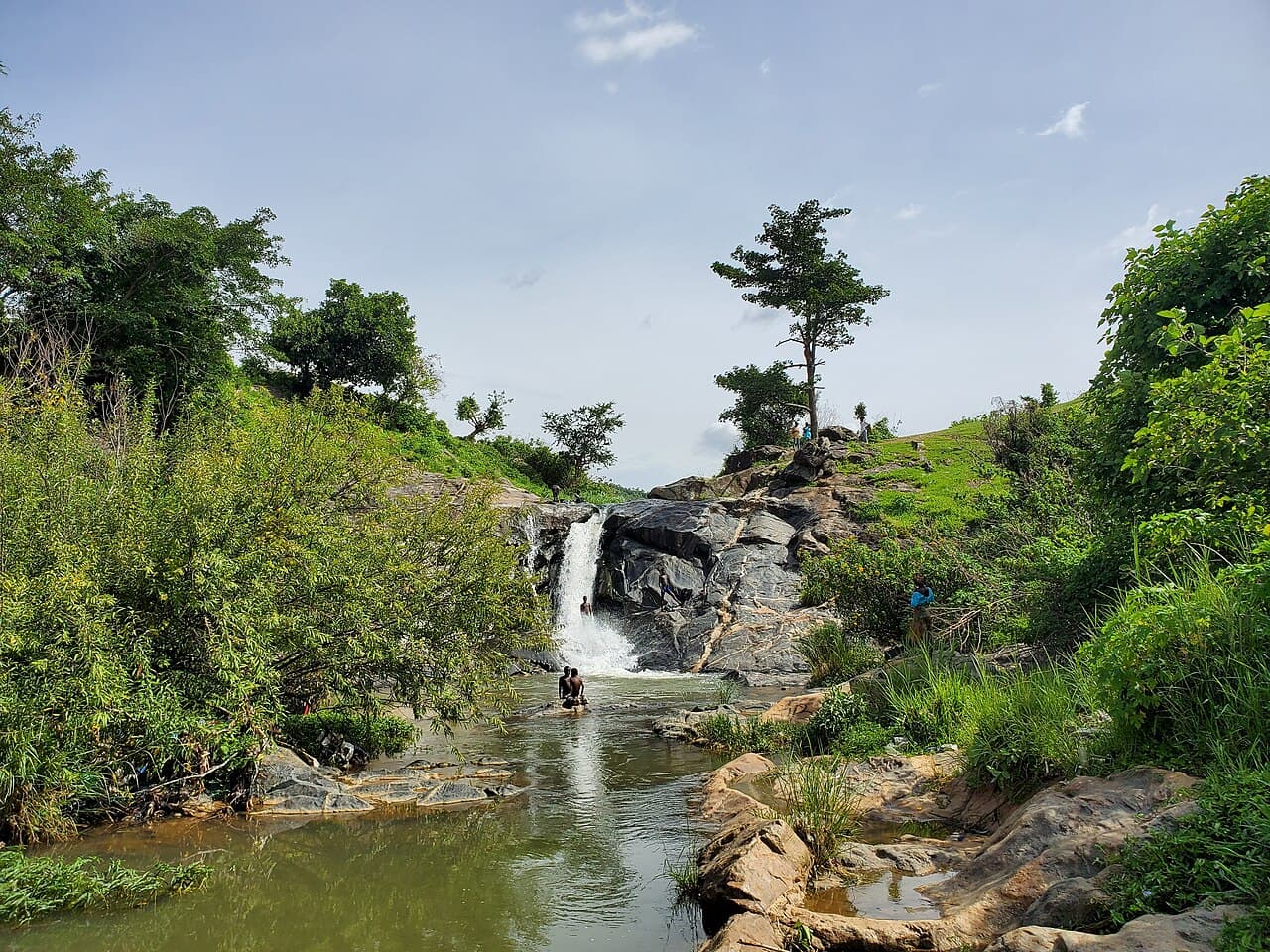 Image shows people swimming at the waterfall, Mazah Hills, Jos.